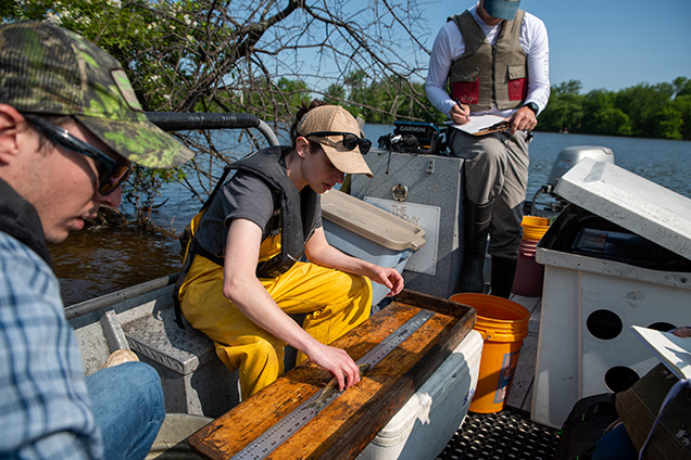 Academy fisheries staff measure fish size.